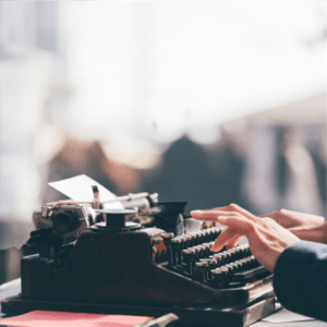 person typing on manual typewriter